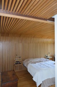 Habillage de mur se prolongeant au plafond et faisant office de tête de lit Habillage de mur se prolongeant au plafond et faisant office de tête de lit