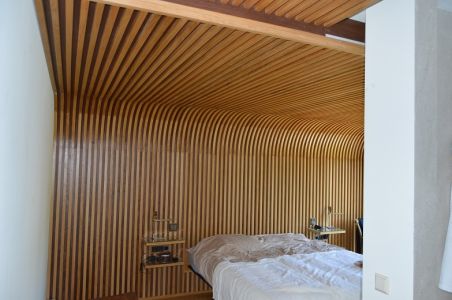 Habillage de mur se prolongeant au plafond et faisant office de tête de lit Habillage de mur se prolongeant au plafond et faisant office de tête de lit