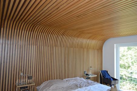 Habillage de mur se prolongeant au plafond et faisant office de tête de lit Habillage de mur se prolongeant au plafond et faisant office de tête de lit