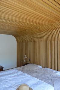 Habillage de mur se prolongeant au plafond et faisant office de tête de lit Habillage de mur se prolongeant au plafond et faisant office de tête de lit