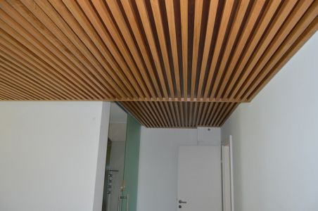 Habillage de mur se prolongeant au plafond et faisant office de tête de lit Habillage de mur se prolongeant au plafond et faisant office de tête de lit