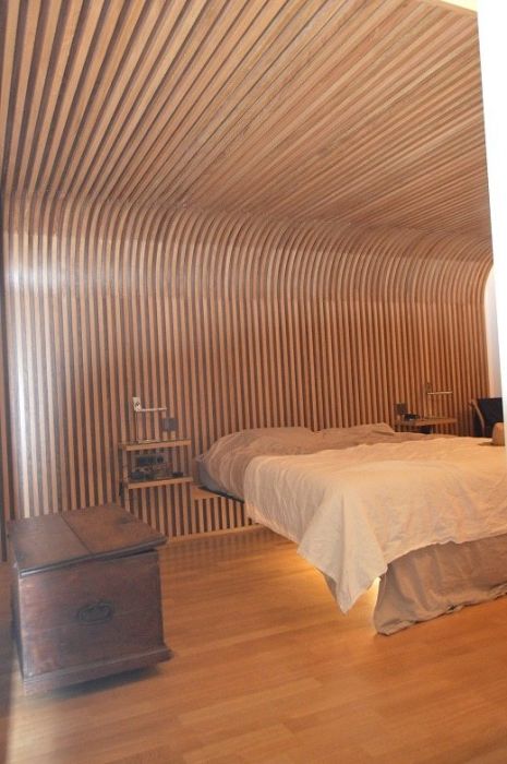 Habillage de mur se prolongeant au plafond et faisant office de tête de lit Habillage de mur se prolongeant au plafond et faisant office de tête de lit